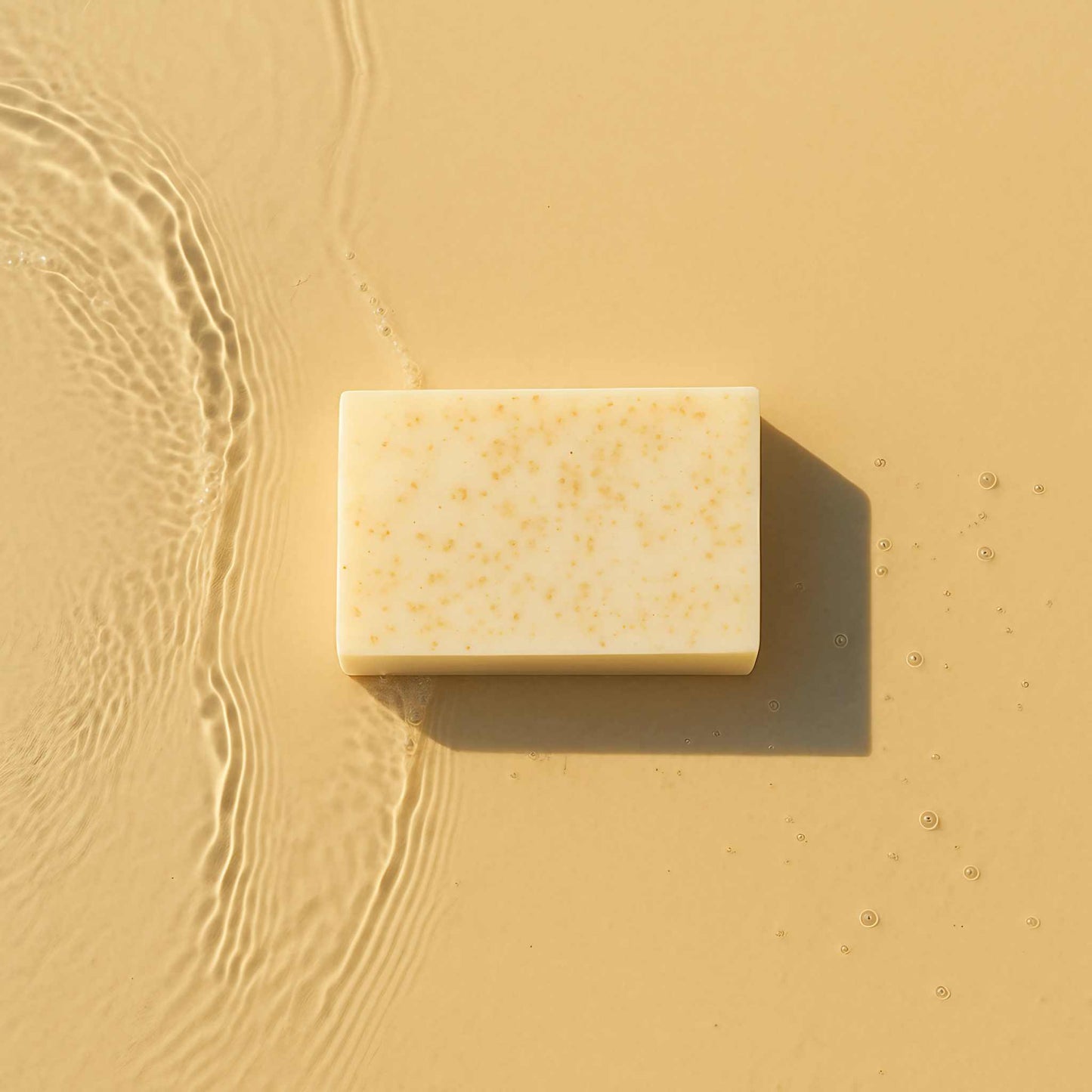 Handmade oatmeal soap bar on beige background, ideal for moisturizing and soothing dry skin.
