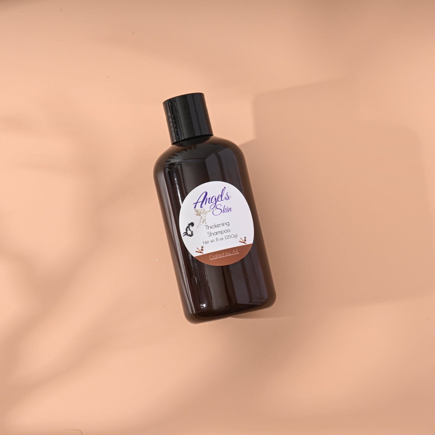 Hair Thickening Shampoo bottle on a peach background.