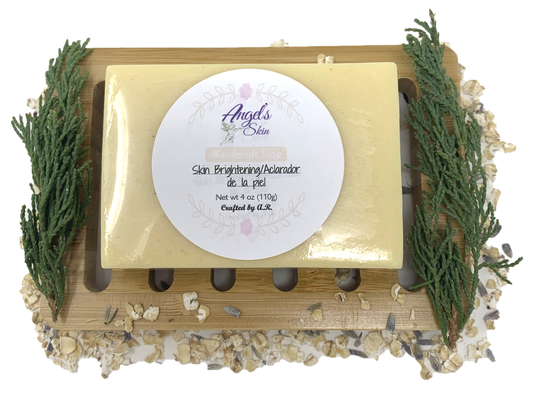 Skin brightening soap with kojic acid for dark spots on wooden tray with natural herbs.
