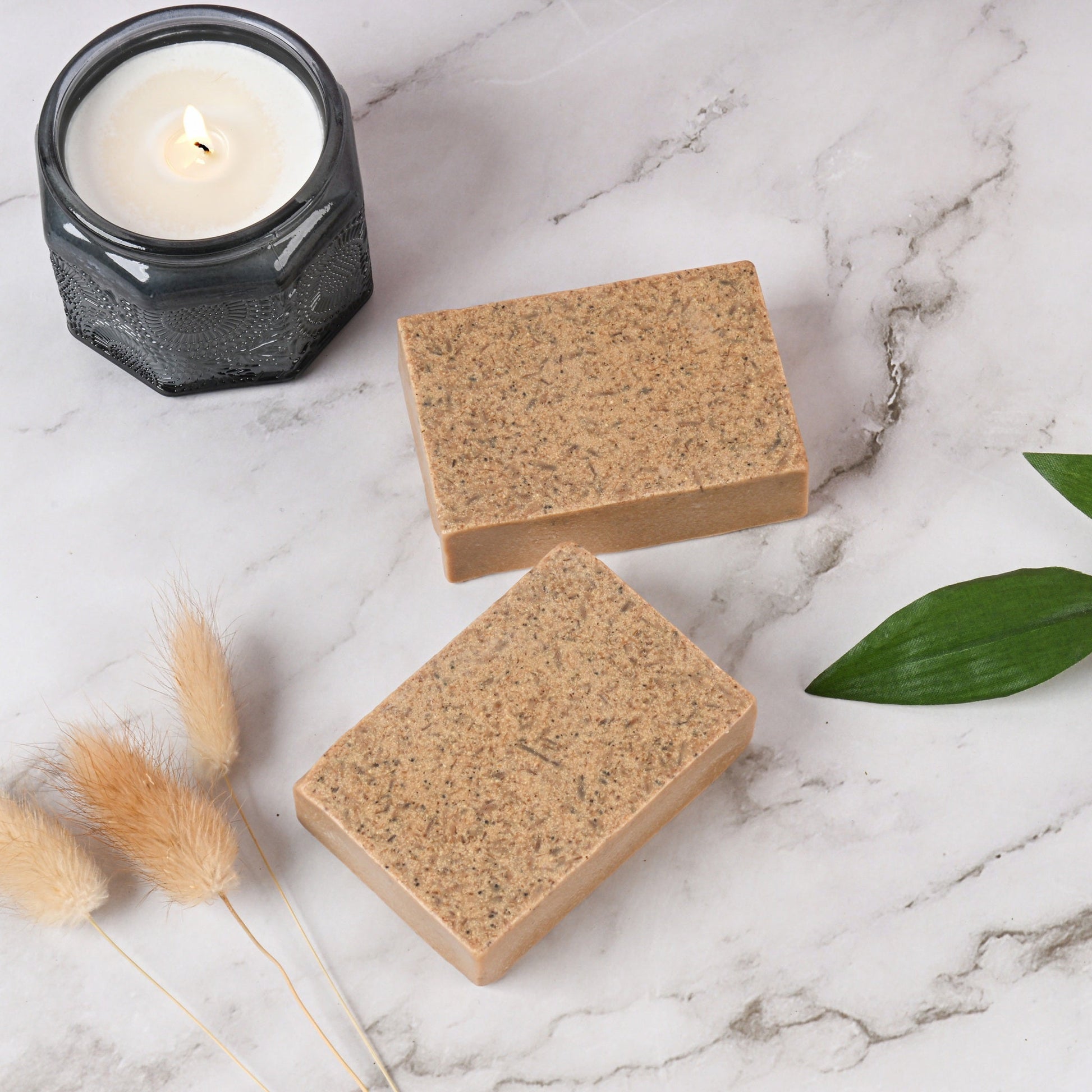 Handmade face wash soap bars for acne on marble with candle and leaves.